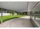 A covered patio looks out onto a large grassy back yard with a white fence at 1180 Eden Isle Ne Blvd, St Petersburg, FL 33704