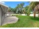 Spacious concrete patio extends to a wide green lawn shaded by large trees in a fully fenced private backyard at 1180 Eden Isle Ne Blvd, St Petersburg, FL 33704