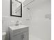 A bathroom with a white tiled shower, updated vanity, and framed mirror at 1180 Eden Isle Ne Blvd, St Petersburg, FL 33704