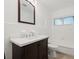 Bright bathroom features a wooden vanity, white countertop, and tiled walls surrounding a bathtub and window at 1180 Eden Isle Ne Blvd, St Petersburg, FL 33704