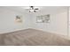 A bright bedroom features neutral carpet, two windows, and a ceiling fan at 1180 Eden Isle Ne Blvd, St Petersburg, FL 33704