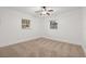 This bright bedroom features neutral carpet, two windows, and a ceiling fan at 1180 Eden Isle Ne Blvd, St Petersburg, FL 33704