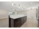 Large dark wood kitchen island with drawers and white countertop, pendant lights, and open to living room at 1180 Eden Isle Ne Blvd, St Petersburg, FL 33704