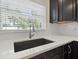 Close-up of the kitchen sink with a white countertop and window view at 1180 Eden Isle Ne Blvd, St Petersburg, FL 33704