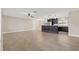 Spacious living room with tile flooring and ceiling fan, open to kitchen island with bar seating and pendant lighting at 1180 Eden Isle Ne Blvd, St Petersburg, FL 33704