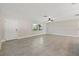 Bright, open living room with neutral walls, tile floor and ceiling fan, door to outside, and large window at 1180 Eden Isle Ne Blvd, St Petersburg, FL 33704