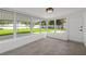 Sunroom features tile floor, white walls, many windows, and a back yard view at 1180 Eden Isle Ne Blvd, St Petersburg, FL 33704