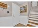 Entryway with wood stairs, wainscoting, a beach-themed painting, and a door with a keypad lock at 130 Brightwater Dr # 5, Clearwater Beach, FL 33767