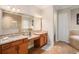 Elegant bathroom featuring granite countertops, tiled floors, and a large mirror with vanity lighting at 13305 Fawn Lily Dr, Riverview, FL 33579