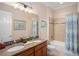 Bright bathroom with double sink vanity, tile shower, and a large window for natural light at 13305 Fawn Lily Dr, Riverview, FL 33579