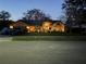 Exterior view of a single story home with brick and wood accents and mature trees at twilight at 1550 Chukar Rdg, Palm Harbor, FL 34683