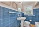 Bathroom with pedestal sink, blue tiled walls, and a bright window at 1611 E Henry Ave, Tampa, FL 33610