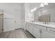 Bathroom features double sink vanity, large mirror, and tiled shower with glass door at 17069 Moonflower Dr, Venice, FL 34293