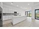 Spacious open-concept kitchen with a large island, tile flooring, stainless steel appliances, and natural light at 17069 Moonflower Dr, Venice, FL 34293