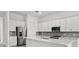 Modern kitchen with stainless steel appliances, white cabinets, and a center island with a quartz countertop at 17069 Moonflower Dr, Venice, FL 34293