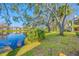 Scenic backyard view featuring a tranquil lake, mature trees, and lush greenery creating a peaceful and picturesque setting at 1735 Lake Cypress Dr, Safety Harbor, FL 34695