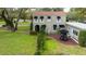 Charming home with mature landscaping, a rear patio, and a lush green lawn at 215 Willowick Ave, Temple Terrace, FL 33617