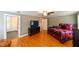 Spacious bedroom featuring hardwood floors, open doors to other rooms, and large tv at 215 Willowick Ave, Temple Terrace, FL 33617