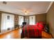 Bedroom featuring hardwood floors, white curtains, and natural light from the two windows at 215 Willowick Ave, Temple Terrace, FL 33617
