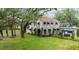 Charming two-story home with a red tile roof, mature trees, and a green lawn at 215 Willowick Ave, Temple Terrace, FL 33617