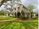 Charming two-story home with classic Spanish tile roof, black awnings, and professionally landscaped yard at 215 Willowick Ave, Temple Terrace, FL 33617