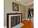 Close-up of a fireplace featuring a marble hearth and decorative screen, with hardwood floors at 215 Willowick Ave, Temple Terrace, FL 33617