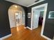 Hallway with hardwood floors, arched doorway, and doorways leading to various rooms at 215 Willowick Ave, Temple Terrace, FL 33617