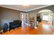 View of a music room featuring a piano, hardwood floors, and arched doorways to other parts of the house at 215 Willowick Ave, Temple Terrace, FL 33617