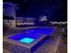 Swimming pool and attached hot tub illuminated at night with blue lighting at 215 Willowick Ave, Temple Terrace, FL 33617