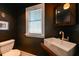Contemporary powder room featuring a vessel sink, modern fixtures, and dark, stylish decor at 215 Willowick Ave, Temple Terrace, FL 33617