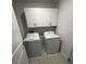 Convenient laundry room with washer, dryer, and white storage cabinets at 2359 Lanier Rd, Zephyrhills, FL 33541