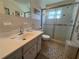 Bathroom with a white single sink vanity, mosaic tile floors, and a sliding glass door shower at 2431 Franciscan Dr # 45, Clearwater, FL 33763