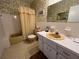Retro bathroom with a yellow tub, vintage sink, and patterned wallpaper at 2431 Franciscan Dr # 45, Clearwater, FL 33763