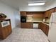 Well-lit kitchen with oak cabinetry and white appliances at 2431 Franciscan Dr # 45, Clearwater, FL 33763