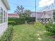 Fenced backyard with mature landscaping, lush grass, and a playset at 2514 W Morrison Ave, Tampa, FL 33629