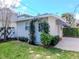 Charming backyard view of a detached garage with green foliage and a blue sky above at 2514 W Morrison Ave, Tampa, FL 33629