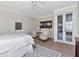 Well-lit bedroom with neutral tones, hardwood floors, french doors, and comfortable sitting area at 2514 W Morrison Ave, Tampa, FL 33629