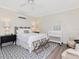 Comfortable bedroom with a queen-size bed, crib, area rug, ceiling fan, and light-colored walls at 2514 W Morrison Ave, Tampa, FL 33629