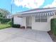 Home exterior with a striped awning and adjacent patio space surrounded by manicured landscaping at 2514 W Morrison Ave, Tampa, FL 33629