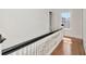 Bright hallway featuring hardwood floors, white railings, and a natural light from a window at 2514 W Morrison Ave, Tampa, FL 33629