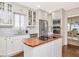 Bright kitchen features white cabinets, marble countertops, a wood-top island, and stainless steel appliances at 2514 W Morrison Ave, Tampa, FL 33629