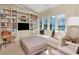 A spacious living room is illuminated by natural light, highlighting built-in bookshelves and stylish, neutral furniture at 2514 W Morrison Ave, Tampa, FL 33629