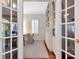 Bright office featuring built-in shelves and cabinets, viewed through glass paneled french doors at 2514 W Morrison Ave, Tampa, FL 33629