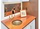 Unique sink with a brass faucet, wooden countertop, and decorative mirror at 2514 W Morrison Ave, Tampa, FL 33629