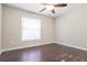 Cozy bedroom featuring a ceiling fan, window with blinds, and rich dark wood-look flooring for a warm, inviting feel at 29636 Tee Shot Dr, San Antonio, FL 33576