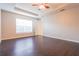Spacious main bedroom with dark hardwood floors, tray ceiling, ceiling fan, and natural light at 29636 Tee Shot Dr, San Antonio, FL 33576
