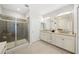 Elegant bathroom with glass enclosed shower, granite double vanity, and stylish modern lighting at 30045 Southwell Ln, Wesley Chapel, FL 33543