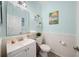 Charming powder room with pastel walls, white wainscoting, decorative mirror and stylish fixtures at 30045 Southwell Ln, Wesley Chapel, FL 33543