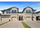 Inviting townhomes featuring garages and stylish architectural details under a clear blue sky at 30045 Southwell Ln, Wesley Chapel, FL 33543