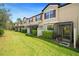 View of townhomes with screened lanais and well-maintained green lawn in a bright, sunny setting at 30045 Southwell Ln, Wesley Chapel, FL 33543